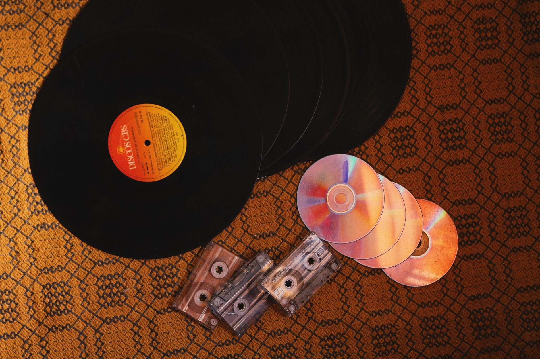 Collection of retro music formats including vinyl records and CDs